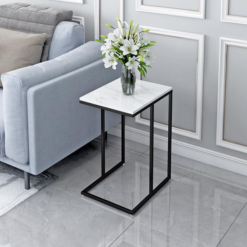Black C-frame side table with a pale rectangular top